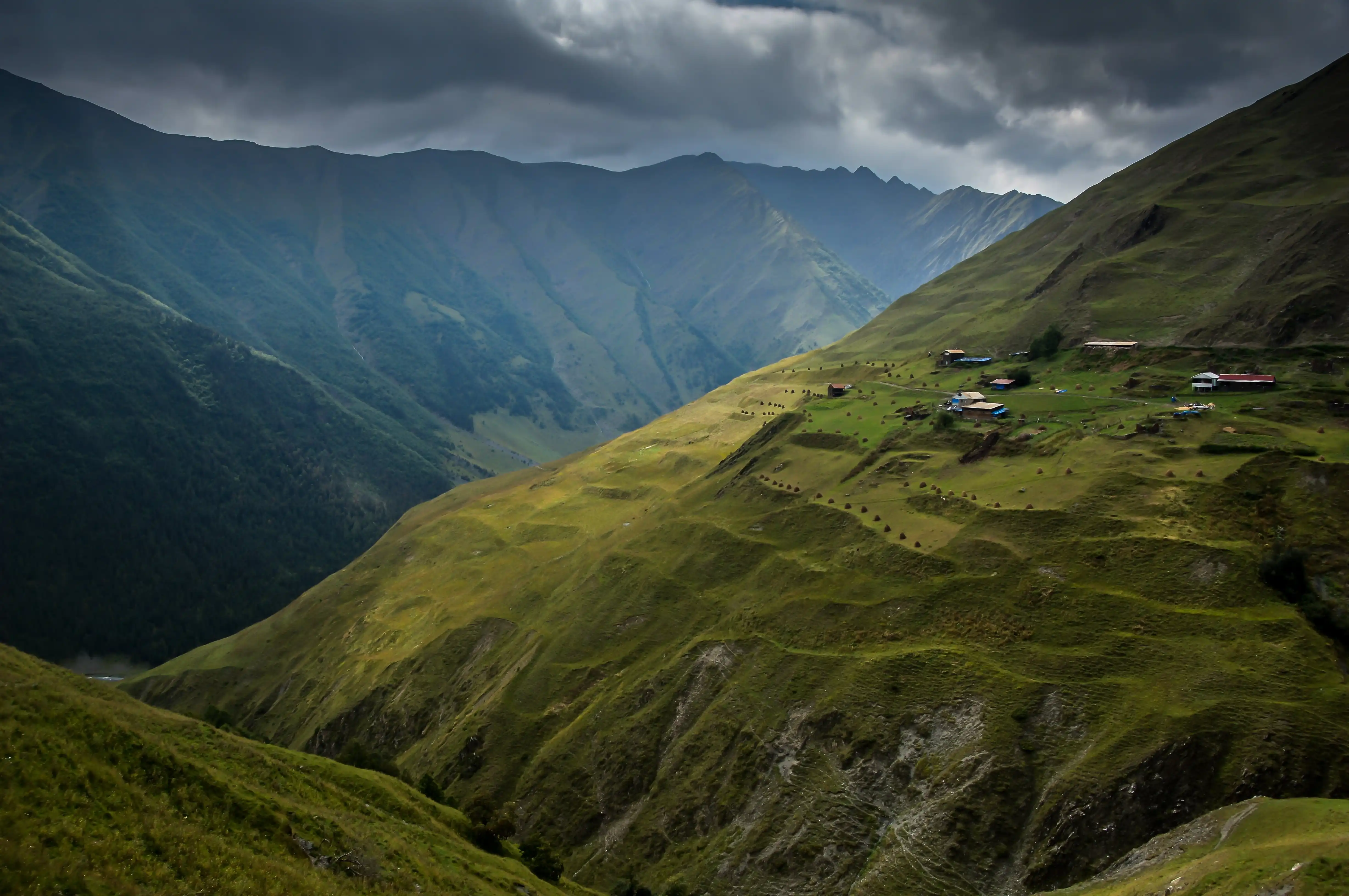 Green mountain valleys under dramatic clouds in Georgia.